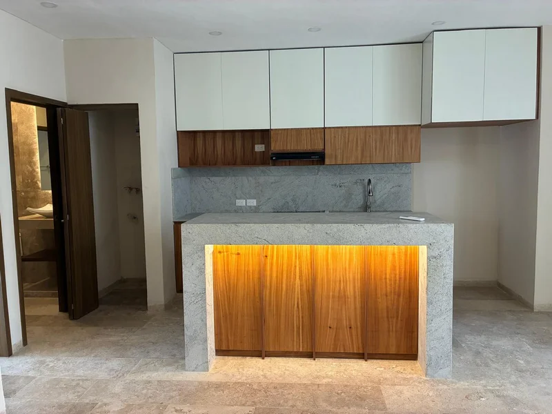 Cocina integral moderna con barra de granito en departamento en renta en Mérida, Yucatán